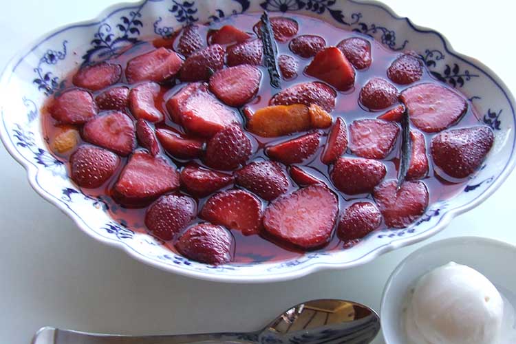 Strawberries and raspberries with orange vanilla sauce and coconut or vanilla ice cream